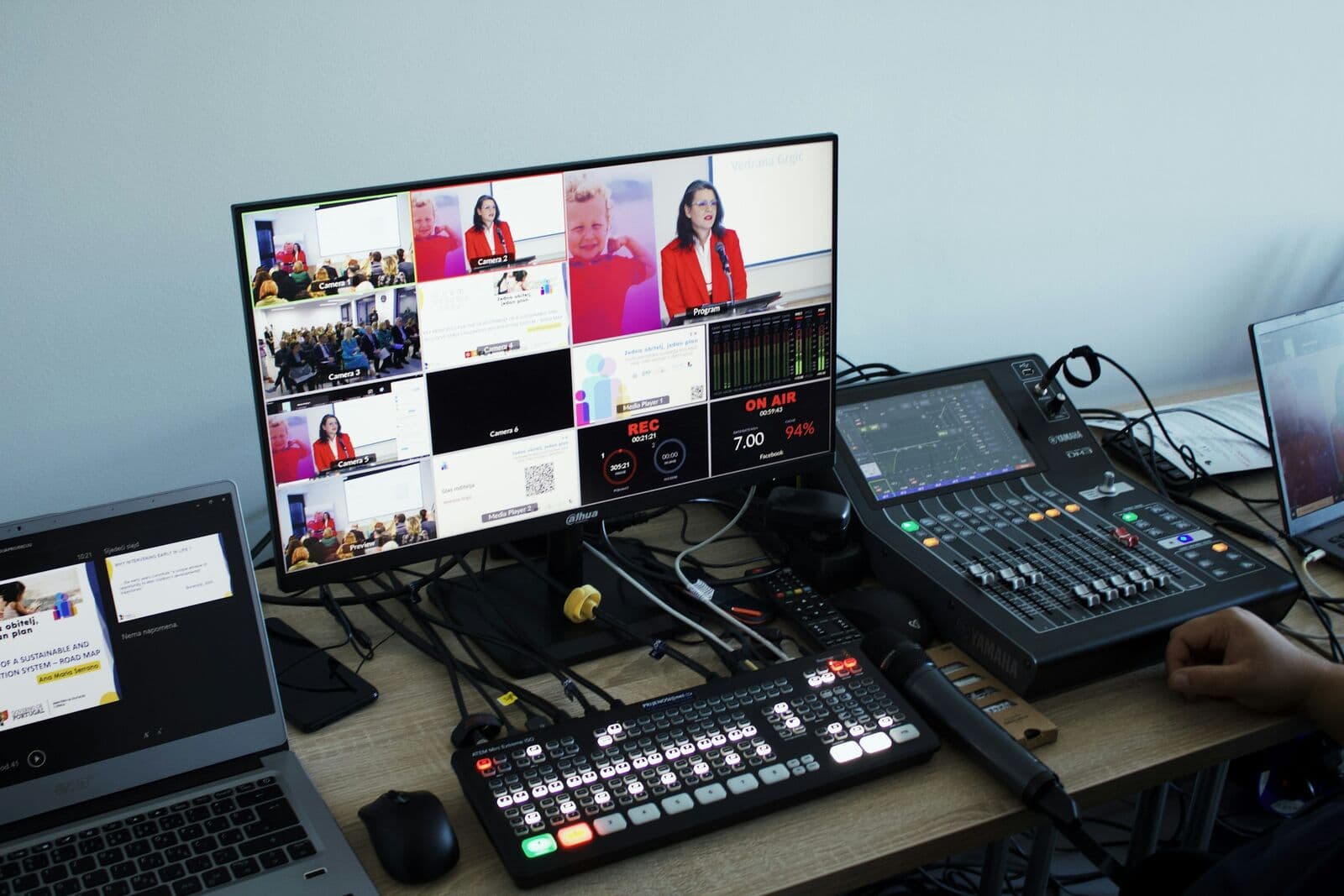 Live production desk with laptops and vision mixer